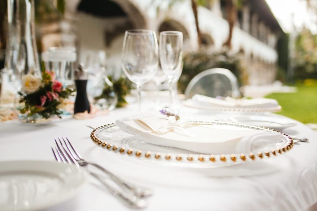 Outdoor wedding reception table setting featuring a white napkin with a lavender spring