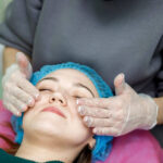Aesthetician in gloves performing a professional facial treatment on a client