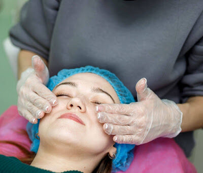 Aesthetician in gloves performing a professional facial treatment on a client