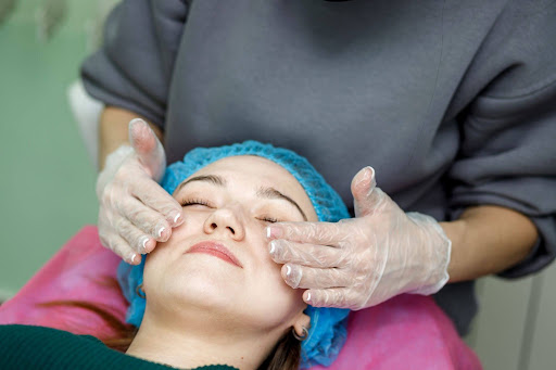 Aesthetician in gloves performing a professional facial treatment on a client